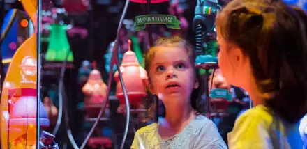 Une enfant emerveillée dans l'exposition Incroyable Cerveau