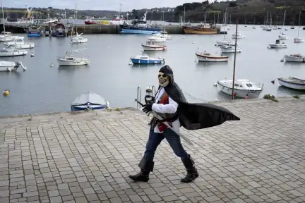 Un homme déguisé en pirate marche sur le port de Douarnenez