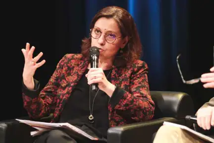 Isabelle Bosse-Platière assise dans un fauteil, micro à la main.