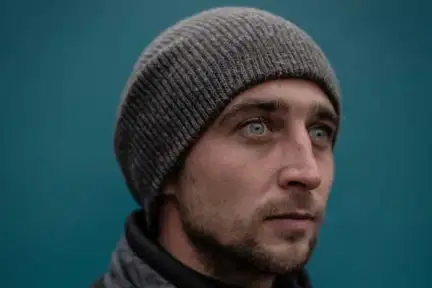 Portrait photographique d'un homme jeune, avec un bonnet.