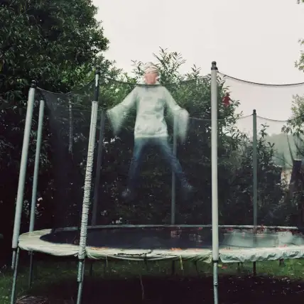 Une photographie qui fige en l'air une personne pendant son saut sur un trampoline.