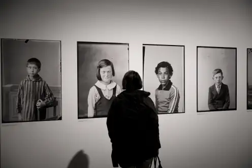 une personne regarde une série de portraits photographiques