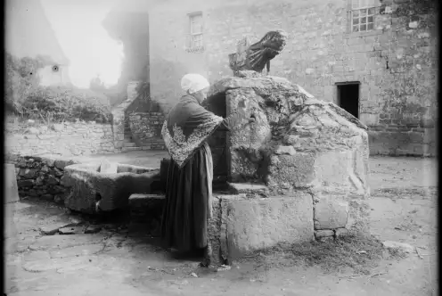 Une femme prend de l'eau au puit