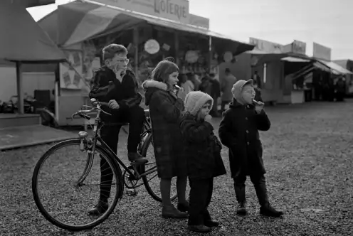 Des enfants posent devant les stands d'une foire au champ de mars.