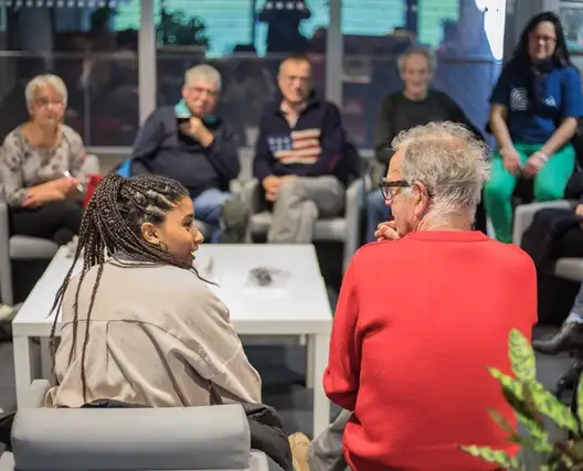 Une photographie d'un RDV 4C dans l'espace Vie du Citoyen des Champs Libres. Deux personnes d'âge différent se regardent.