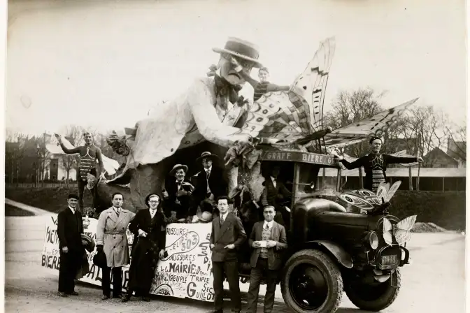 Photographie d'un char de la Mi-Carême, représentant un entomologiste étudiant des papillons, et véhiculé par un camion de la brasserie Graff. Onze personnages sont photographiés, dont Marcel Cruche qui a réalisé le char. Les personnages sur le char sont grimés. Une pancarte est fixée au char, vraisemblablement publicitaire.