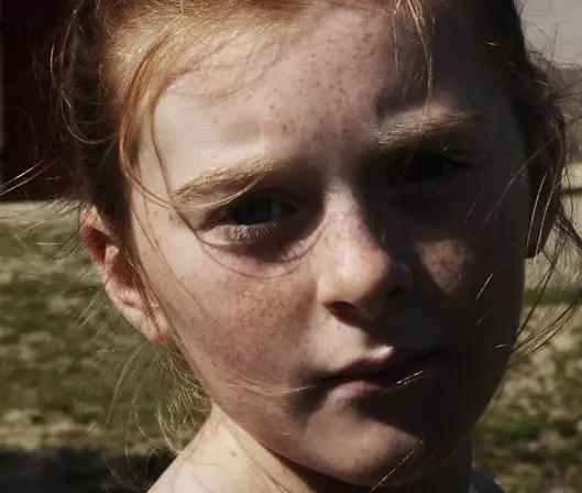 Photographie de Nolwen Brod d'une jeune fille rousse avec des taches de rousseur. Elle a les cheveux attachés, mais décoiffés à cause du vent.