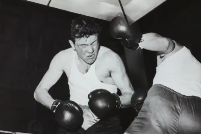 Combat de boxe  avec un boxeur les yeux fermés qui s'apprête à prendre un coup