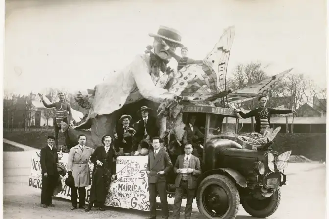 Char de la mi-careme avec un camion portant un grand personnage,  sept personnes posent devant