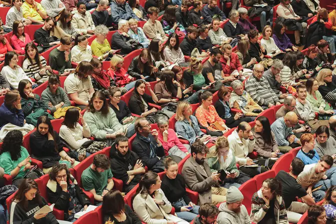 Cette photographie prise de haut nous montre un public assis dans l'auditorium des Champs Libres, à l'occasion de l'événement Nos Futurs 2024.