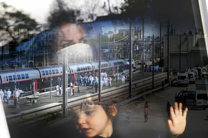 Image obtenue par superposition de deux images numériques couleur : - une photographie prise le 5 avril 2020 intitulée "Bretagne terre d'accueil" qui montre l'arrivée des transferts sanitaires en gare de Rennes, par TGV, les hôpitaux d'Ile-de-France étant surchargés, - une photographie prise le 27 mars 2020 intitulée "Tous confinés", portrait à travers la vitre d'un appartement d'une jeune mère et de sa fille.