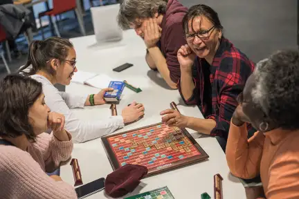 Cinq personnes jouent au scrabble en anglais