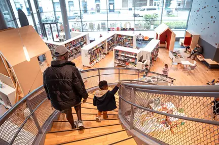 Un papa et son enfant dans l'escalier de l'espace enfants