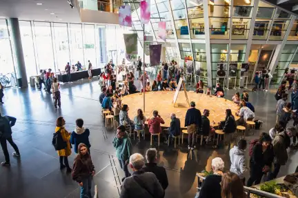 Vue panoramique du hall des Champs Libres avec la plateforme centrale autours de laquelle les publics sont installés