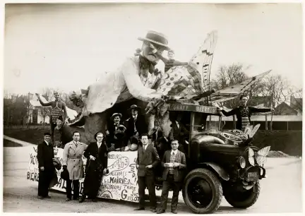 Photographie d'un char de la Mi-Carême, représentant un entomologiste étudiant des papillons, et véhiculé par un camion de la brasserie Graff. Onze personnages sont photographiés, dont Marcel Cruche qui a réalisé le char. Les personnages sur le char sont grimés. Une pancarte est fixée au char, vraisemblablement publicitaire.