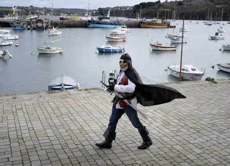 Un homme déguisé en pirate marche sur le port de Douarnenez