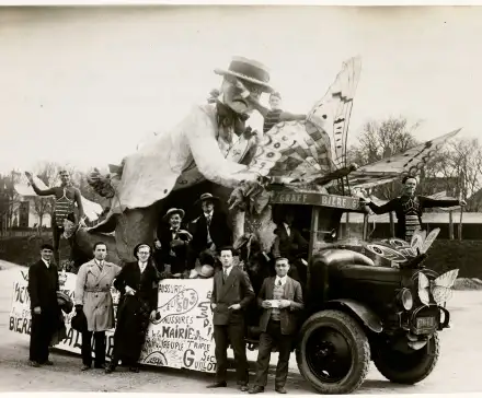 Photographie d'un char de la Mi-Carême, représentant un entomologiste étudiant des papillons, et véhiculé par un camion de la brasserie Graff. Onze personnages sont photographiés, dont Marcel Cruche qui a réalisé le char. Les personnages sur le char sont grimés. Une pancarte est fixée au char, vraisemblablement publicitaire.