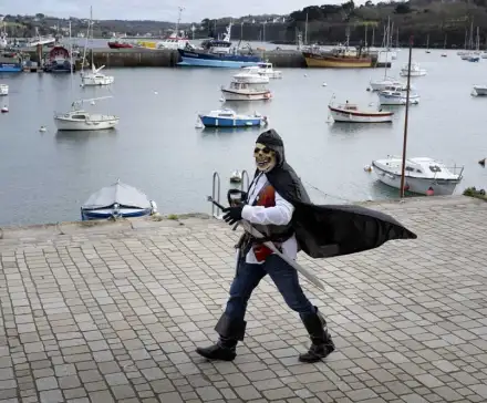 Un homme déguisé en pirate marche sur le port de Douarnenez