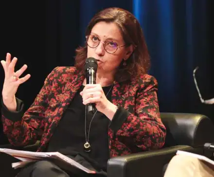 Isabelle Bosse-Platière assise dans un fauteil, micro à la main.