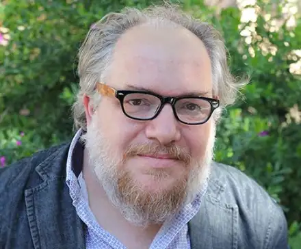 Une photographie de Mathias Énard, portant des lunettes de vue noires, face à l'objectif.