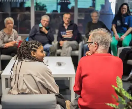 Une photographie d'un RDV 4C dans l'espace Vie du Citoyen des Champs Libres. Deux personnes d'âge différent se regardent.